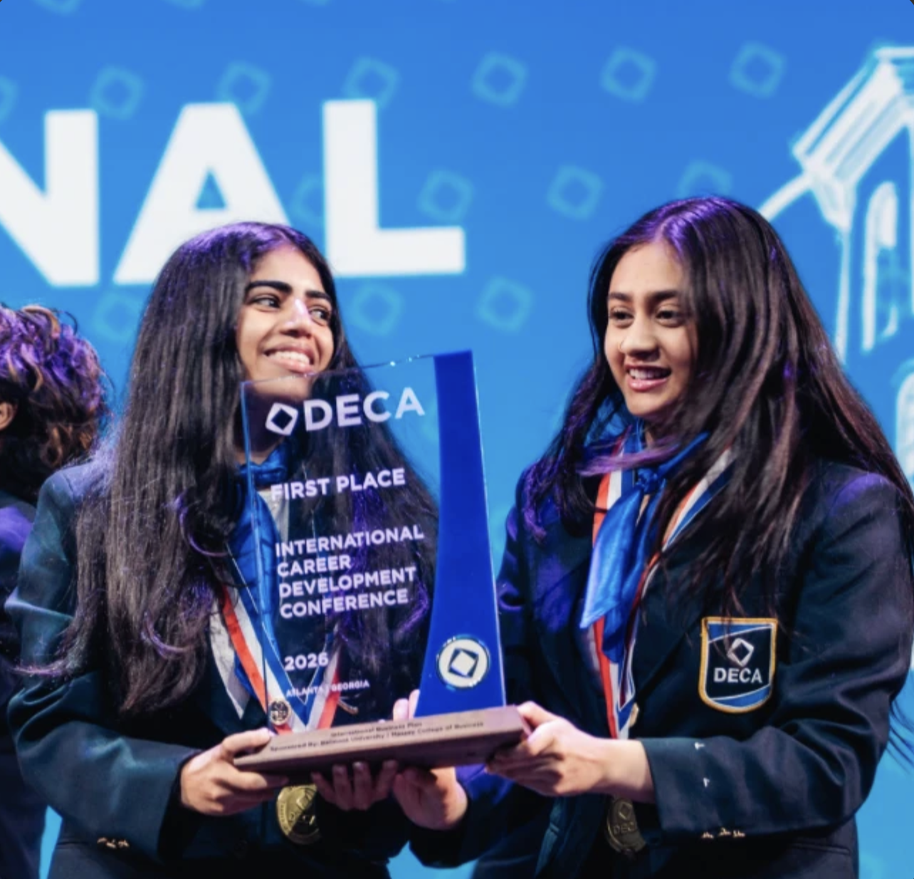 Anvitha and a teammate holding their 1st place trophy at DECA ICDC